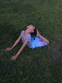 High angle view of smiling young woman on grassy field