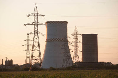 Low angle view of electricity pylon on field against sky