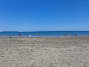 Scenic view of beach against clear blue sky