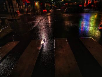 Illuminated city street during rainy season at night