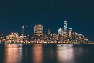 Illuminated buildings in city against sky at night