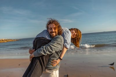 Portrait of man standing at beach against sky