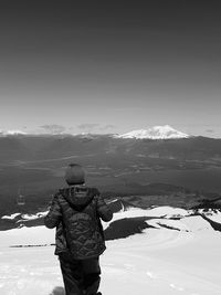 Rear view of woman standing on snow covered landscape