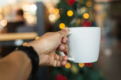 Cropped hand of woman holding coffee