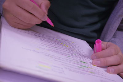 Midsection of man holding pen over paper