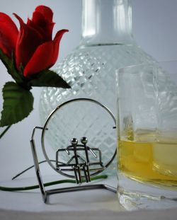 Close-up of rose and whiskey on table