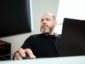 Portrait of man using laptop at home