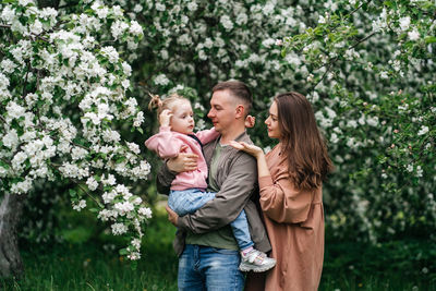 Family mom mom baby daughter in the garden blooming apple trees