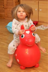 Portrait of cute girl sitting on inflatable toy at home