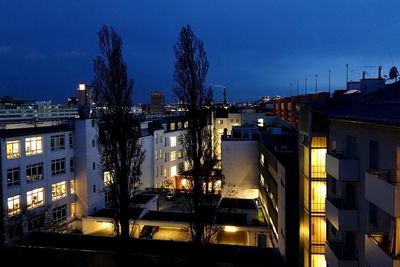 Illuminated buildings against sky at night