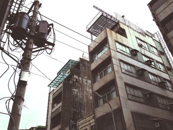 Low angle view of transformer in front of building