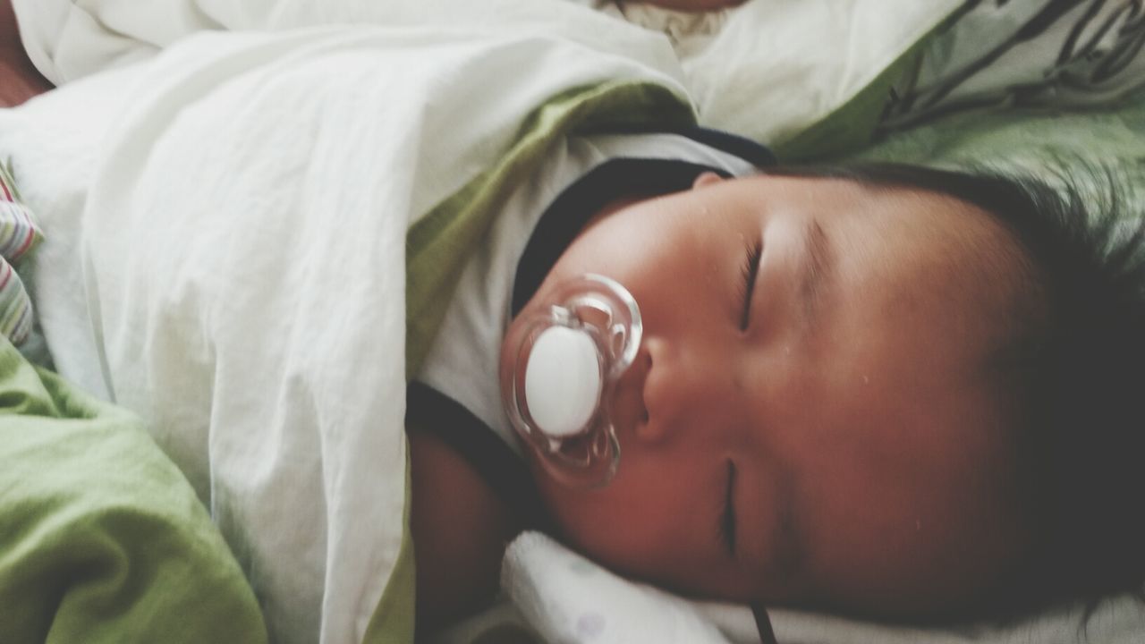 indoors, bed, baby, babyhood, childhood, innocence, close-up, sleeping, lifestyles, relaxation, toddler, person, headshot, cute, beginnings, eyes closed, unknown gender, newborn