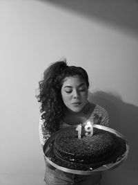 Portrait of a 19 year old girl blowing out her candles