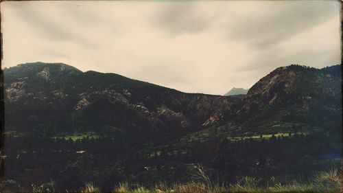 Scenic view of mountains against cloudy sky