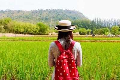 Rear view of woman standing in field