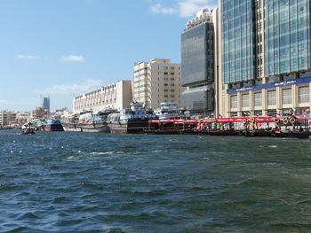 Buildings by sea against sky in city