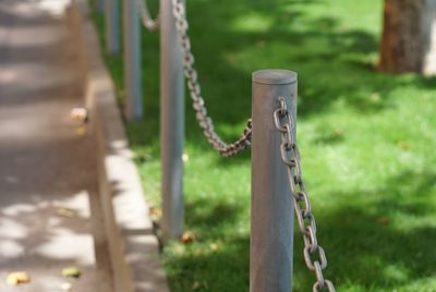 Close-up of rusty chain on wooden fence