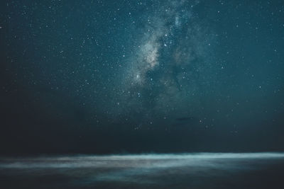 Scenic view of sea against star field at night