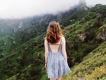 Rear view of young woman standing on mountain