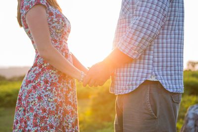 Midsection of couple holding hands