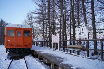 Train on snow covered railroad tracks against sky