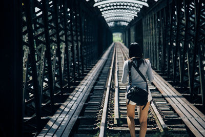 Rear view of woman walking on railway bridge