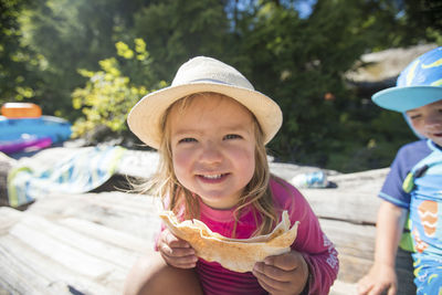 Cute toddler girl eating pita bread at the beach.