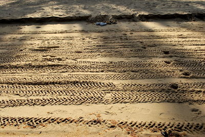 Close-up of tire tracks on sand