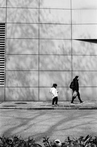 People walking on footpath in city