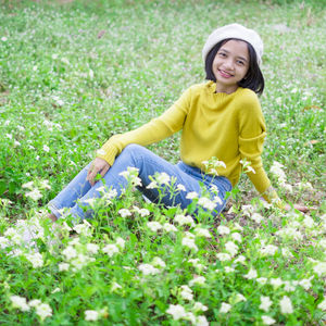 Portrait of a smiling young woman sitting on field