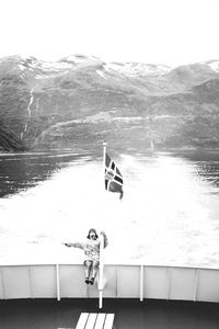 Man in boat on sea against mountain