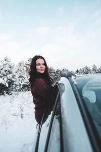 Woman in snow against sky during winter