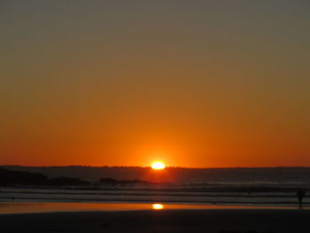 Scenic view of sea against orange sky