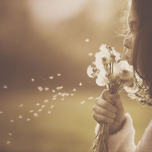 Girl blowing dandelions