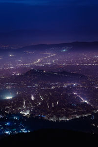 Aerial view of illuminated cityscape against sky at night