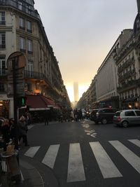 Cars on city street against sky