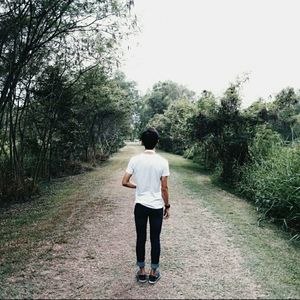 Rear view of woman walking on footpath