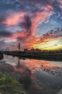 Scenic view of factory against sky during sunset