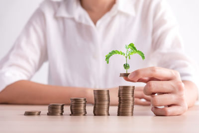 Midsection of man holding coins on table