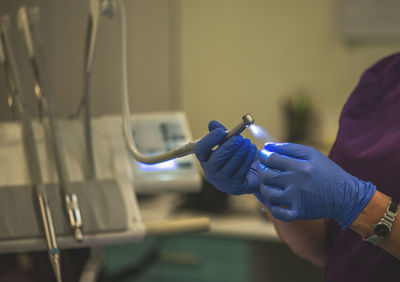 Midsection of dentist holding dental drill