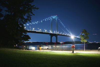 Illuminated bridge over river at night