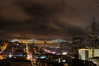 High angle view of illuminated buildings against cloudy sky