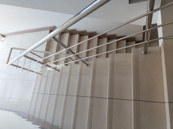 Modern design of stanless steel pipes handrail and ceramic tiles staircase in a public building