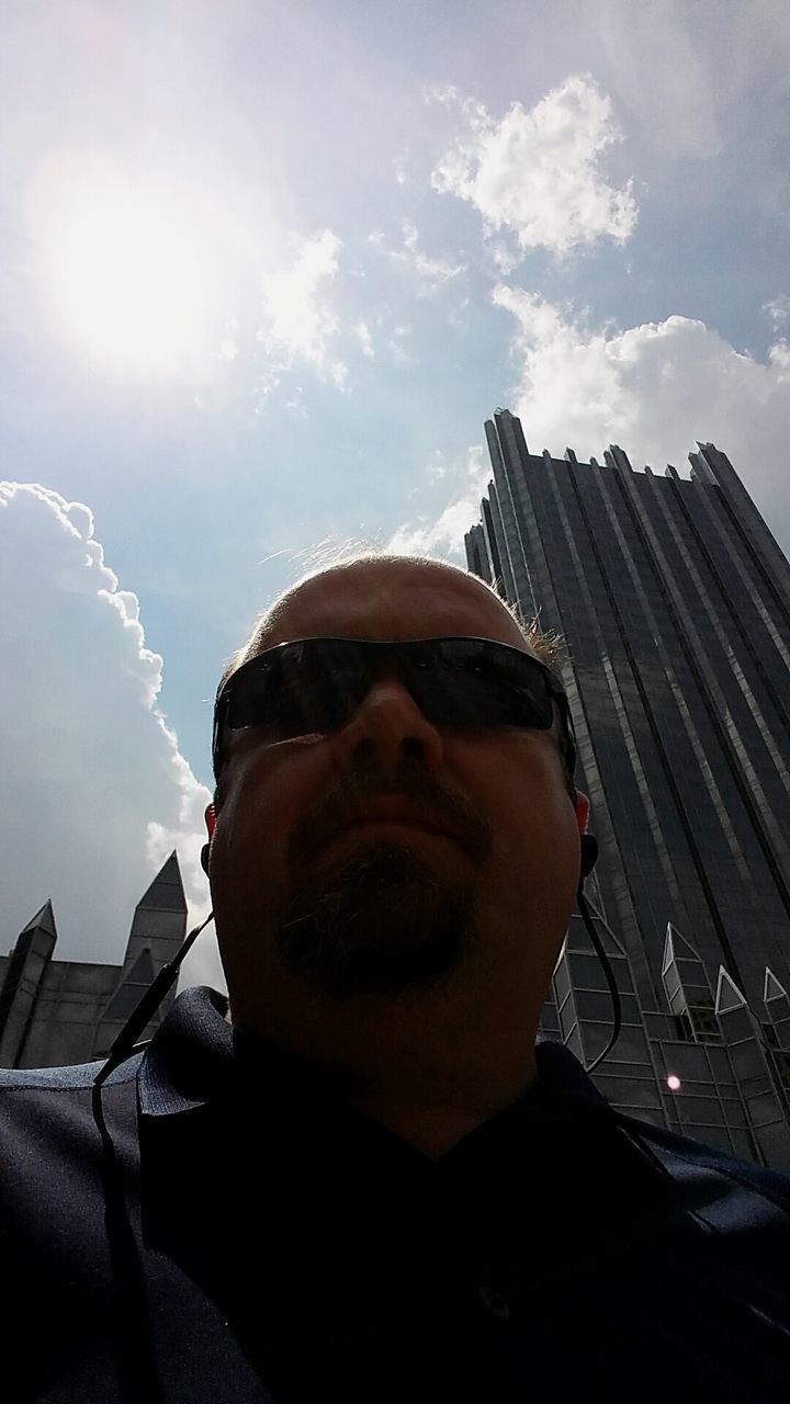 headshot, young adult, lifestyles, person, young men, leisure activity, building exterior, architecture, mid adult men, sunglasses, built structure, portrait, mid adult, sky, head and shoulders, looking at camera, front view, beard