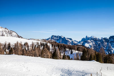 Scenic view of snowcapped mountains against clear blue sky