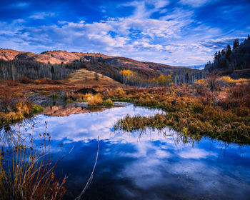 Scenic view of lake by mountain against sky during autumn