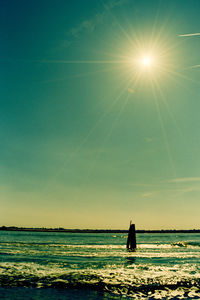 Silhouette woman standing on beach against clear sky