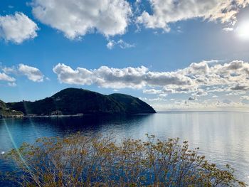 Scenic view of lake by mountains against sky