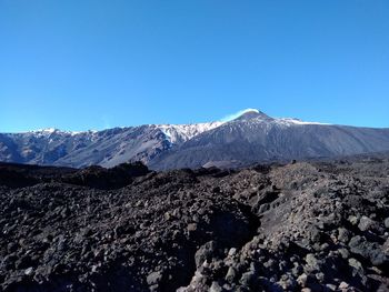 Scenic view of snowcapped mountains against clear blue sky