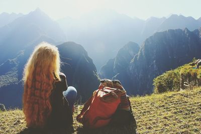 Rear view of woman standing on field against mountain